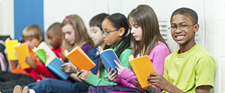 students sitting against lockers reading